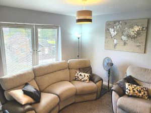 ein Wohnzimmer mit einer Couch und einem Fenster in der Unterkunft Parkside Apartment Normanton in Wakefield