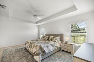 Un dormitorio con una cama y un ventilador de techo. en Spacious Lake View 3BR in The Villages With Golf Cart & Patio, en Sumterville 26 fotos más