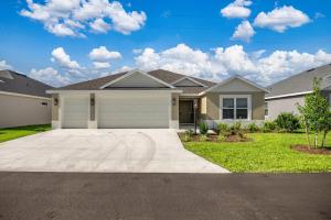 una casa grande con garaje en un patio en Spacious Lake View 3BR in The Villages With Golf Cart & Patio, en Sumterville