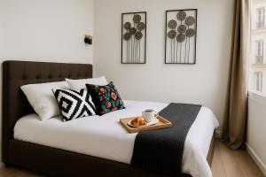 une chambre avec un lit avec un plateau de nourriture dessus dans l'établissement LE MARAIS-SAINT MARTIN working & living, à Paris