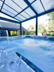 a hot tub with wine glasses on a table at Bahnhofsromantik trifft Luxus - Alter Bahnhof von Kruft in Kruft