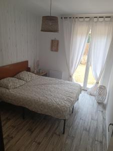 Un dormitorio con una cama y una ventana grande. en Villa Ilanga, en Soulac-sur-Mer