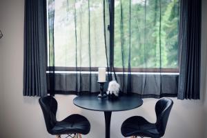 a table and two chairs in front of a window at Orbit ALDERAN-Home Stay in Matsuda