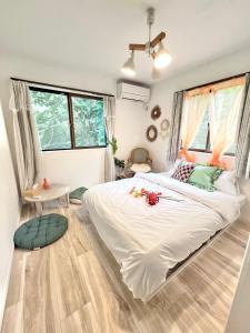 a bedroom with a large white bed with flowers on it at Orbit ALDERAN 民宿 in Matsuda