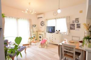 a living room with a table and a tv at Orbit ALDERAN-Home Stay in Matsuda