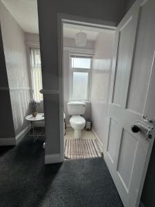 een badkamer met een toilet en een raam bij Home from Home in Belfast in Belfast