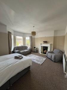 een slaapkamer met 2 bedden, een bank en een open haard bij Home from Home in Belfast in Belfast