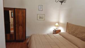 ein Schlafzimmer mit einem Bett und einer Lampe auf einem Tisch in der Unterkunft 4 stagioni primavera in Piana