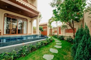 a house with a swimming pool in the yard at Hoian Tranquil Beach Villa in An Bàn (2)