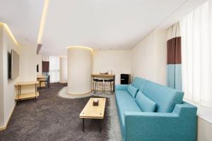 a living room with a blue couch and a table at Hotel 108, Hong Kong in Hong Kong