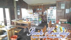 a store with wooden tables and chairs in a room at Rante Homestay & Cafe in Biau