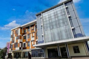 プカンバルにあるCollection O Stefani City Hotelの側面のガラス窓のあるオフィスビル