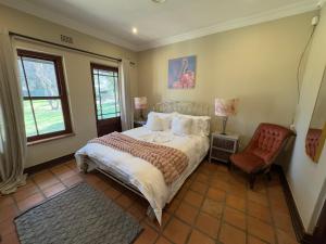 una camera da letto con un letto, una sedia e una finestra di Stay Nest Guesthouse a Chartwell Altre 23 foto