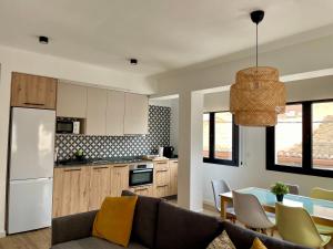 a kitchen and living room with a couch and a table at Indalo Mar Menor - Cozy modern stay in Old Town near the beach in Los Alcázares