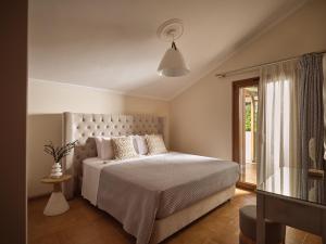 a bedroom with a large bed and a window at Casa Di Cuore Loft - Sea View & Jacuzzi Retreat in Argassi