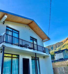 a white house with a balcony on top of it at Hillside Mestia ჰილსაიდ მესტია in Mestia