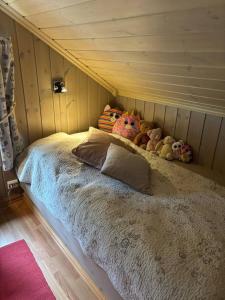 Una cama con animales de peluche en una habitación en Cosy ski-in ski-out mountain cabin with sauna, en Trysil