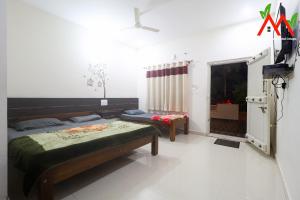 Un dormitorio con dos camas y un televisor. en Nature View Homestay, en Kushālnagar