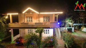 Una casa con luces encima por la noche. en Nature View Homestay, en Kushālnagar 6 fotos más