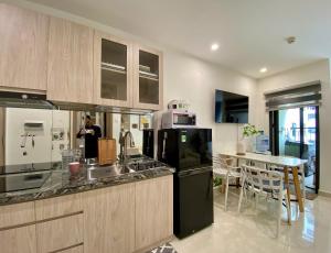 a man is taking a picture of a kitchen at Shi House - Modern Apartment Vinhomes Grand Park - Căn Hộ Studios in Gò Công