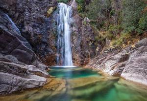 a waterfall in the middle of a pool of water at São Cristóvão Nature Country Hotel in Venda Nova