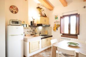 a kitchen with a white refrigerator and a table at La Casa dei Quadri in Ravi