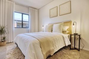 约翰内斯堡Modern Luxury 1BR in Hyde Park的卧室里有一张白色的大床，床边有一扇窗户