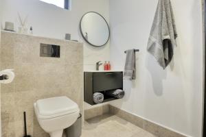 约翰内斯堡Modern Luxury 1BR in Hyde Park的带马桶和镜子的白色浴室 更多10张照片