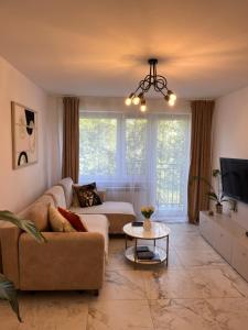 a living room with a couch and a table at Sara Apartament in Turek