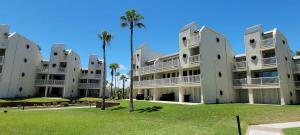 a large building with palm trees in front of it at Bahia Mar #426 in South Padre Island