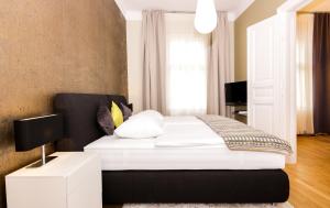 ウィーンにあるAbieshomes Serviced Apartments - Downtownのベッドルーム1室(白いシーツと枕のベッド1台付)