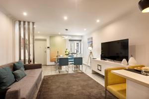 a living room with a couch and a flat screen tv at Casa dos Quatro in Faro
