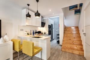 a kitchen with yellow chairs and a kitchen counter at Casa dos Quatro in Faro