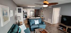 Una sala de estar con un sofá azul y un televisor. en Saida 3-206, en South Padre Island