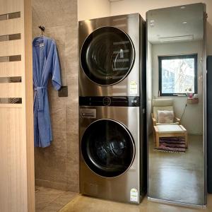 a stainless steel washer and dryer in a room at Rooftop House Seongsu in Seoul