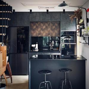 a kitchen with a black counter and stools in it at Rooftop House Seongsu in Seoul