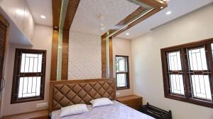 a bedroom with a large bed in a room with windows at Samsthaanam - Luxury 3BHK Villa with Pool in Udupi in Kalyānpur +21 photos