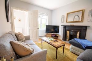 un salon avec un canapé et une cheminée dans l'établissement Cherry Cottage, à Wrexham