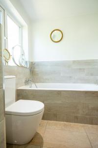 une salle de bain avec toilettes et baignoire dans l'établissement Cherry Cottage, à Wrexham