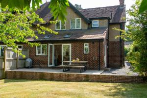 Cette maison en briques dispose d'une terrasse avec une table de pique-nique. dans l'établissement Cherry Cottage, à Wrexham