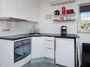 a kitchen with white cabinets and a sink at 4 star holiday home in Gråsten in Gråsten