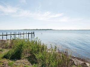 a large body of water with a wooden pier at 4 person holiday home in Gråsten-By Traum in Gråsten