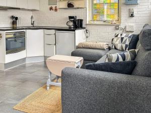 a living room with two couches and a kitchen at 4 star holiday home in Gråsten in Gråsten