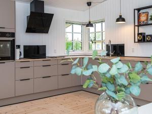 a kitchen with white cabinets and a vase with a plant at Renovated Beach House - By Traum Ferienwohnungen in Juelsminde