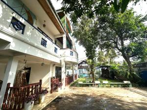 a courtyard of a building with a tree and benches at Orchid Villa Negombo in Negombo