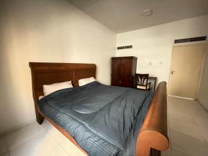una camera da letto con un letto con testiera in legno di Sharjah corniche private room for women only a Sharjah