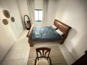 une chambre avec un lit et une chaise dedans dans l'établissement Sharjah corniche private room for women only, à Charjah