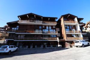 a building with two cars parked in front of it at Nouvelles Residences - Studio équipé pour 4 personnes MAE-7774 in Tignes +4 photos