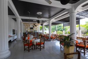 a restaurant with white columns and tables and chairs at The Safiya Hotel, Diani Beach in Diani Beach
