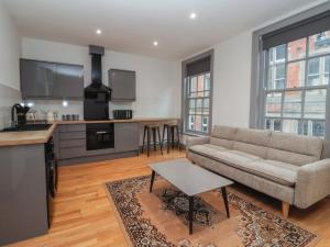 un salon avec un canapé et une cuisine dans l'établissement Apartment 9, à York